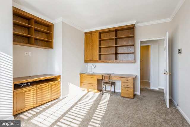 unfurnished office with light carpet, built in desk, and ornamental molding