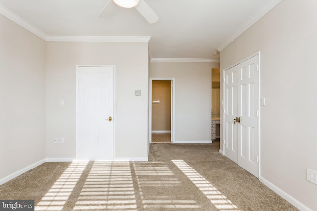 empty room featuring crown molding, carpet floors, and ceiling fan