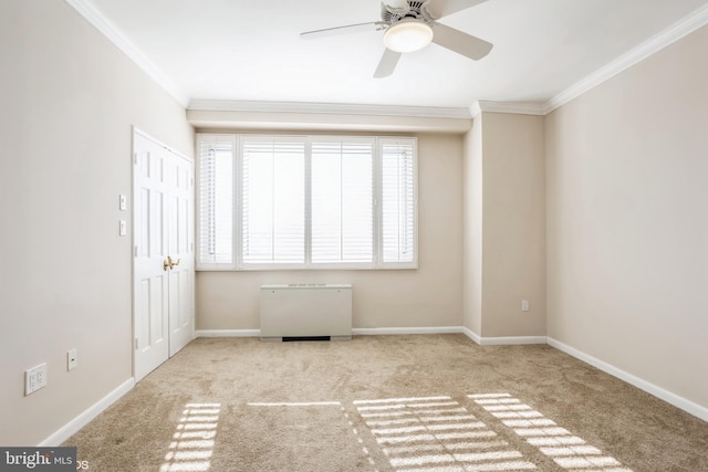 carpeted spare room with crown molding and ceiling fan