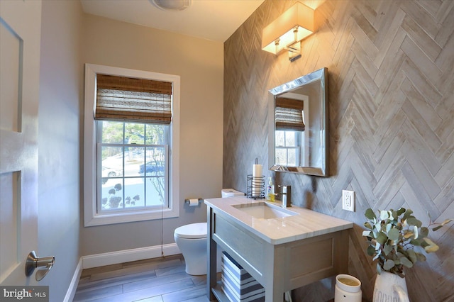 bathroom with vanity, hardwood / wood-style floors, toilet, and a healthy amount of sunlight