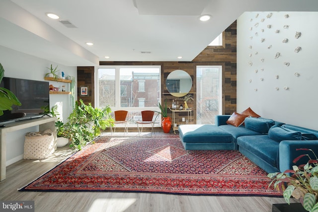 living area featuring a wealth of natural light, visible vents, and wood finished floors