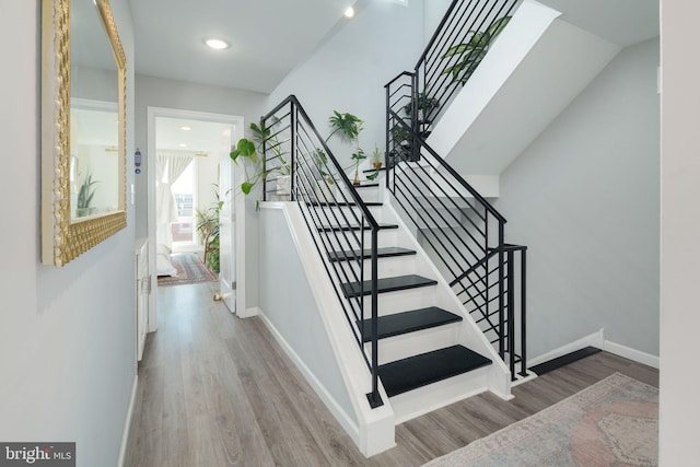 staircase with wood finished floors and baseboards