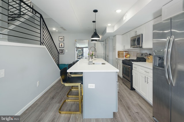 kitchen featuring a sink, light wood-type flooring, white cabinetry, and stainless steel appliances