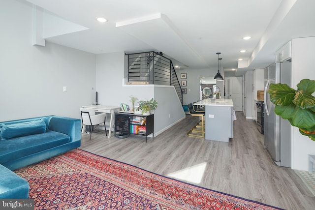 living area with stairs, recessed lighting, light wood-style floors, and baseboards