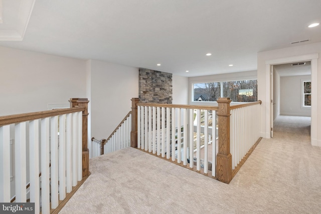 hall featuring light colored carpet and a wealth of natural light