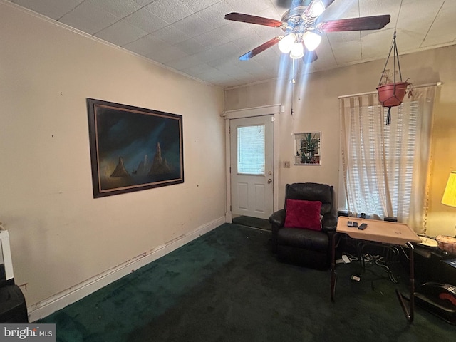 living area with a ceiling fan, carpet flooring, and baseboards