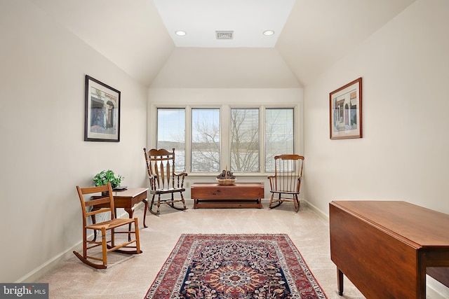 living area with vaulted ceiling and light colored carpet