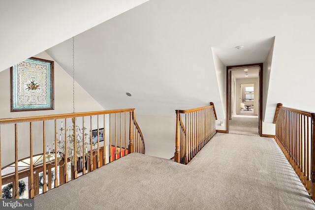 hall with lofted ceiling and carpet floors