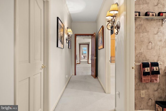 hallway featuring ornamental molding and light colored carpet