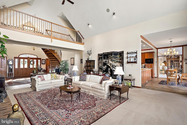 carpeted living room with a notable chandelier and high vaulted ceiling