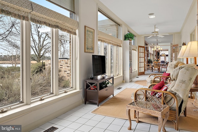 interior space featuring ceiling fan with notable chandelier, plenty of natural light, and light tile patterned floors