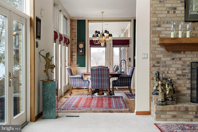 carpeted dining area featuring a healthy amount of sunlight and a chandelier