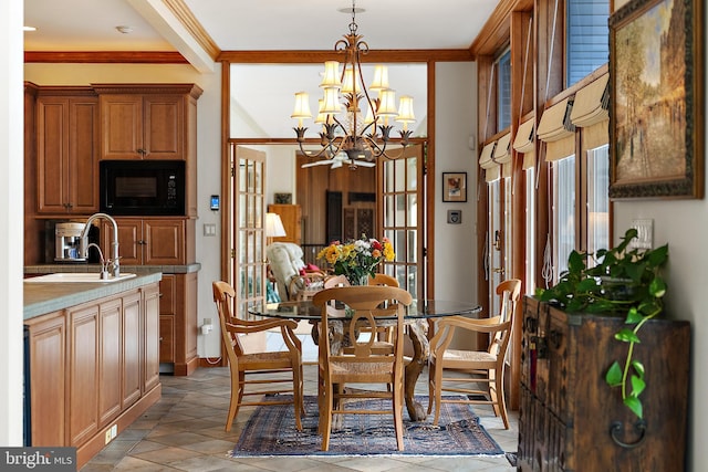 dining room featuring crown molding, sink, and a notable chandelier