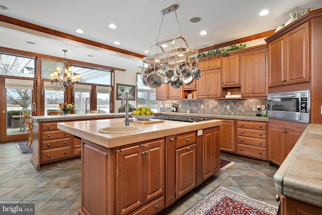 kitchen with decorative light fixtures, sink, backsplash, a center island, and stainless steel appliances