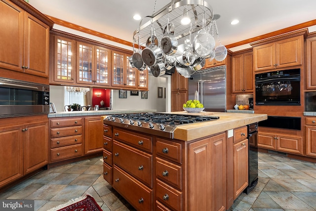 kitchen with hanging light fixtures, a center island, built in appliances, and backsplash