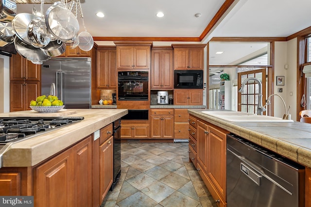 kitchen with sink, crown molding, black appliances, a kitchen island, and backsplash