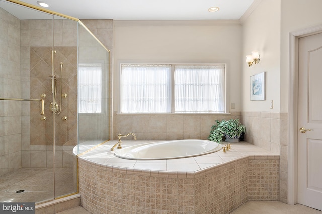 bathroom with ornamental molding and shower with separate bathtub