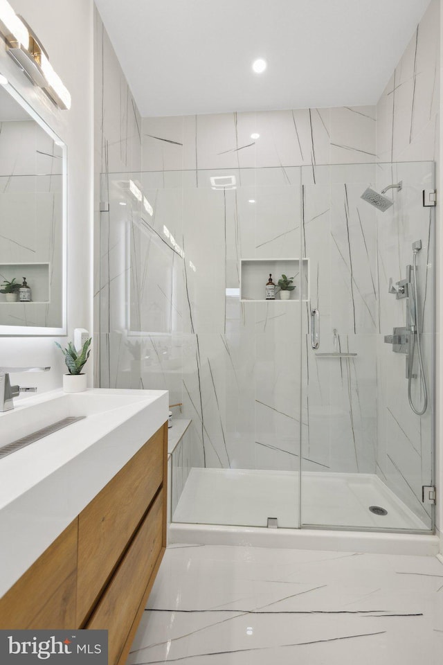 bathroom featuring vanity and a shower with shower door