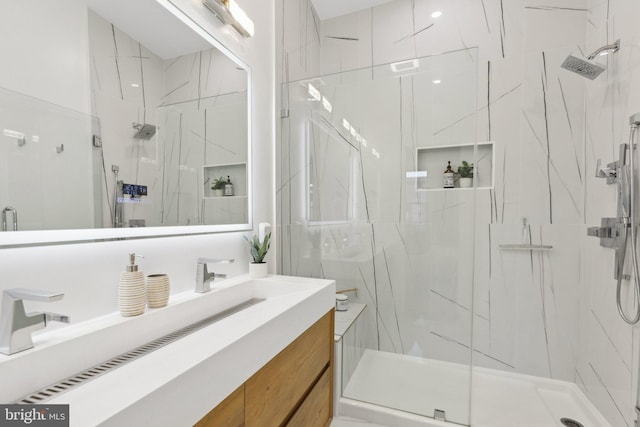 bathroom featuring vanity and a shower with door