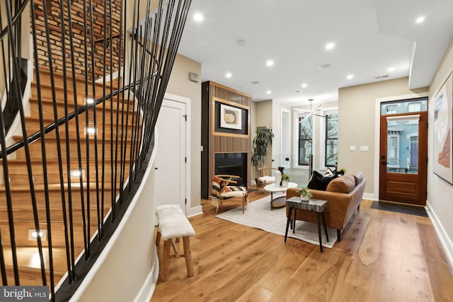 living room featuring hardwood / wood-style flooring and a large fireplace