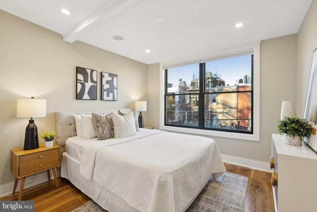 bedroom featuring beam ceiling and dark hardwood / wood-style flooring