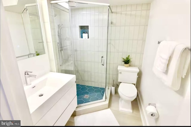 bathroom with vanity, a shower with shower door, and toilet