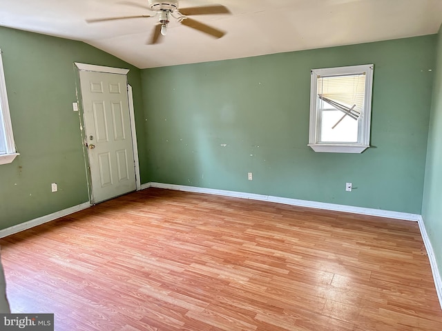 spare room featuring ceiling fan, vaulted ceiling, and light wood-type flooring