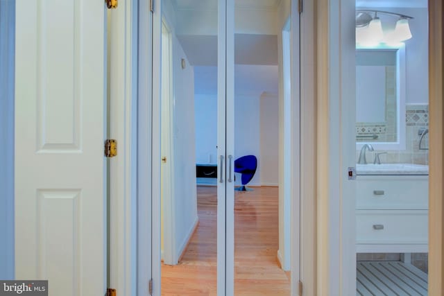 corridor featuring sink and light hardwood / wood-style flooring