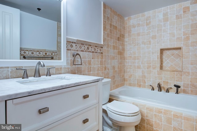 bathroom with a relaxing tiled tub, vanity, toilet, and tile walls