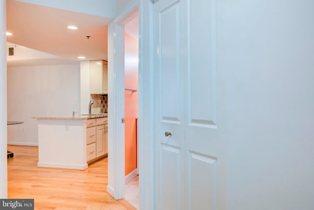 corridor featuring sink and light hardwood / wood-style floors