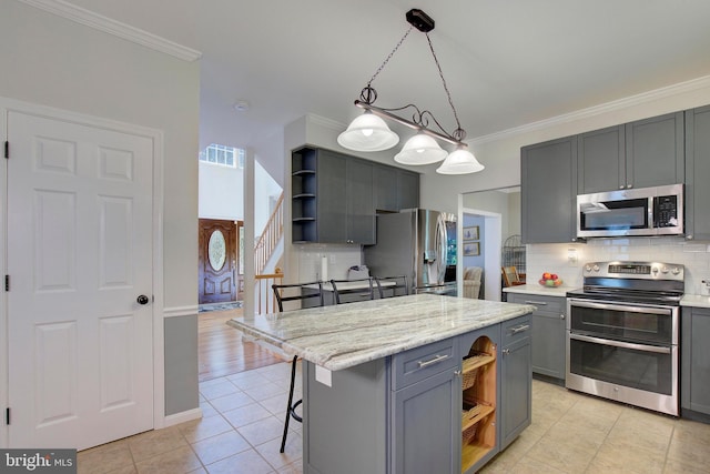 kitchen with gray cabinetry, a center island, a kitchen breakfast bar, pendant lighting, and stainless steel appliances