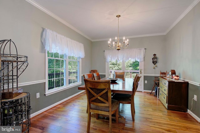 dining space featuring crown molding, a chandelier, and light hardwood / wood-style floors