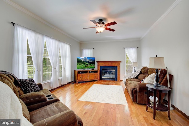 living room with ornamental molding, light hardwood / wood-style floors, and a wealth of natural light