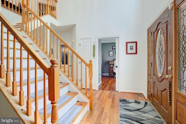 entrance foyer with a high ceiling and hardwood / wood-style floors