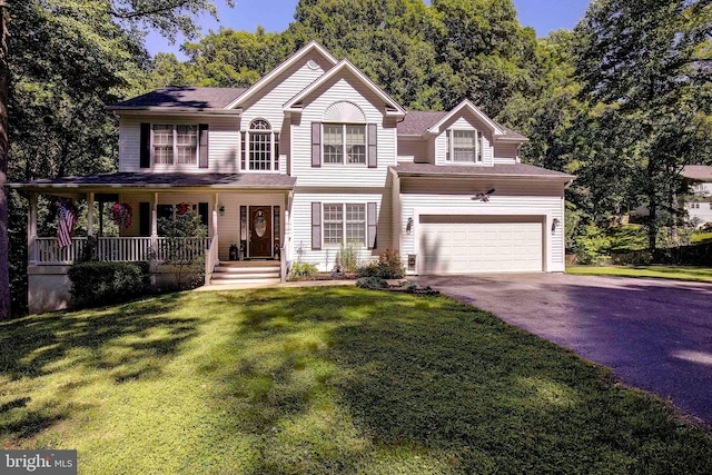 view of front facade with a garage, covered porch, and a front yard