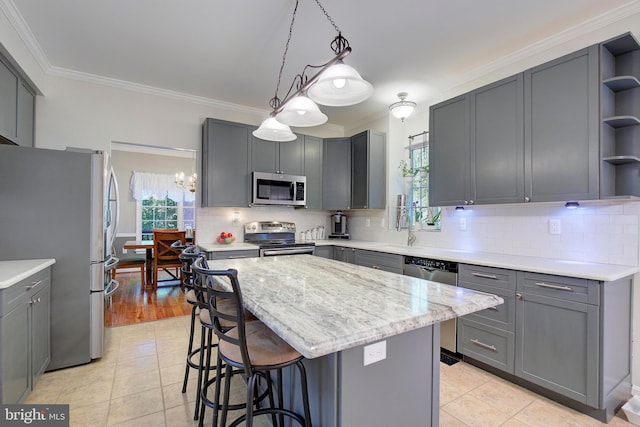 kitchen featuring gray cabinetry, a kitchen island, and appliances with stainless steel finishes