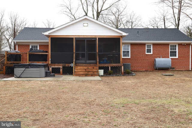 rear view of property with cooling unit, a hot tub, a patio, and a sunroom