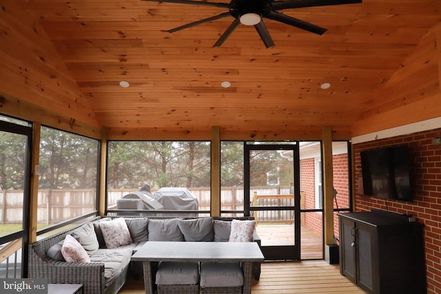 sunroom / solarium featuring lofted ceiling, plenty of natural light, wooden ceiling, and ceiling fan