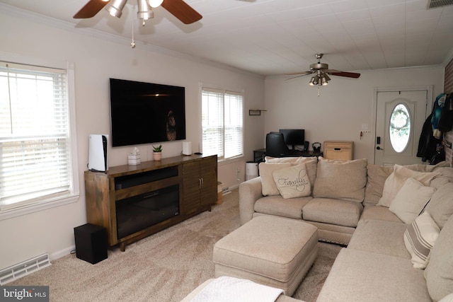 carpeted living room featuring ornamental molding and ceiling fan