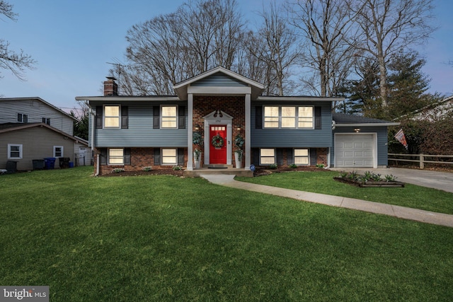 bi-level home featuring a garage and a front yard