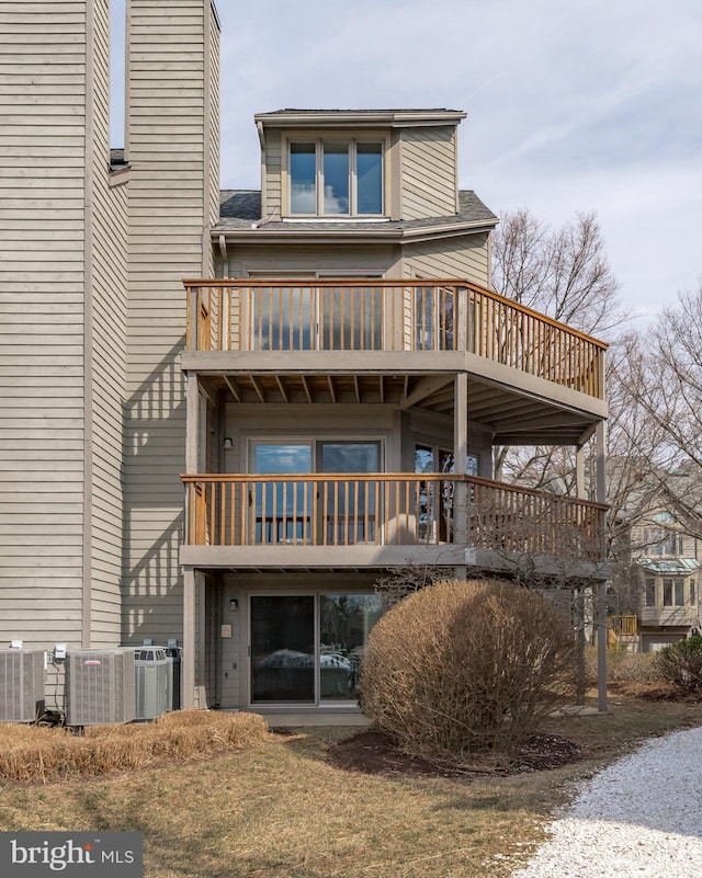 back of property featuring a shingled roof, a balcony, and central air condition unit