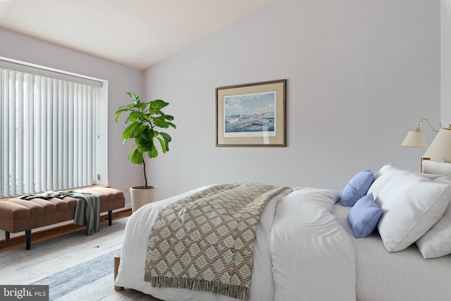 bedroom with light wood finished floors and vaulted ceiling