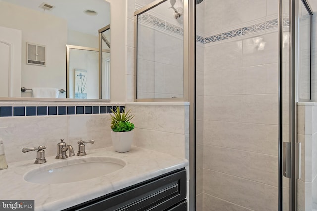 full bath with a stall shower, visible vents, backsplash, and vanity