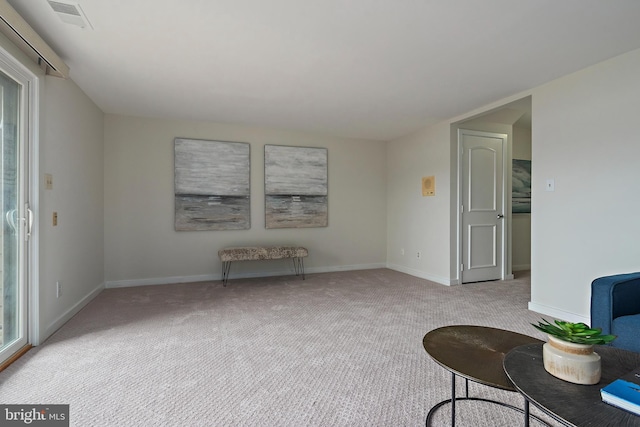 living area featuring carpet flooring, visible vents, and baseboards