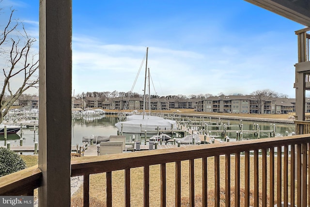 balcony with a dock, a water view, boat lift, and a residential view