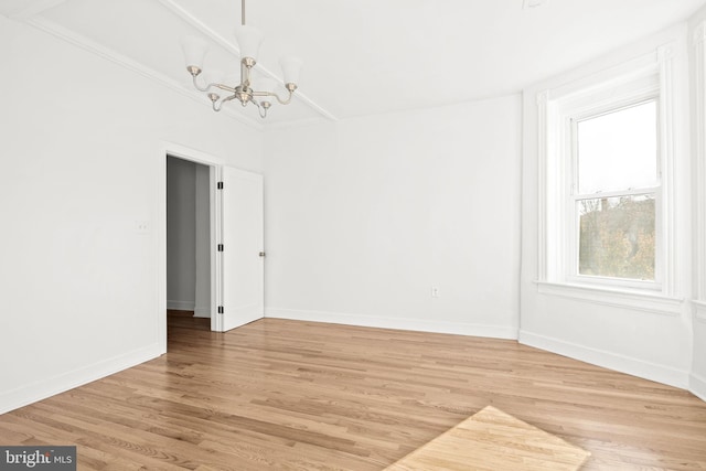 unfurnished room featuring an inviting chandelier and wood-type flooring