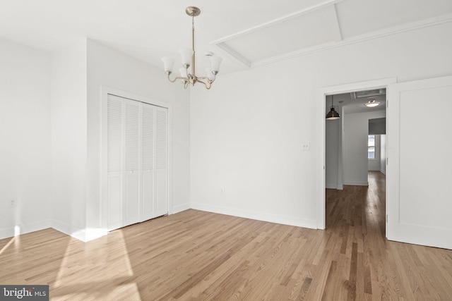 unfurnished room with hardwood / wood-style floors and an inviting chandelier