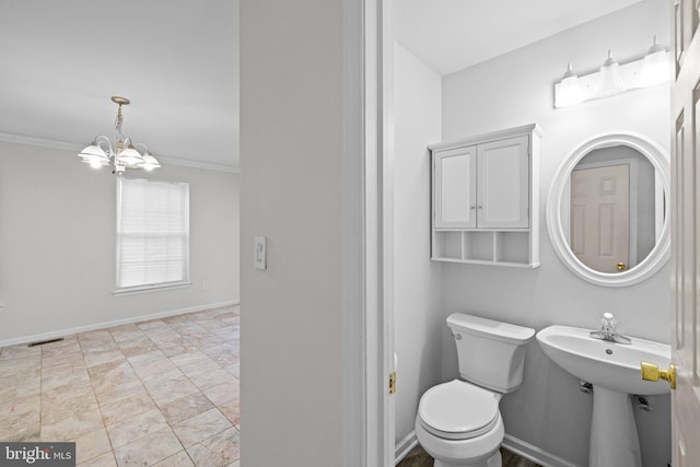 bathroom with crown molding, a chandelier, and toilet