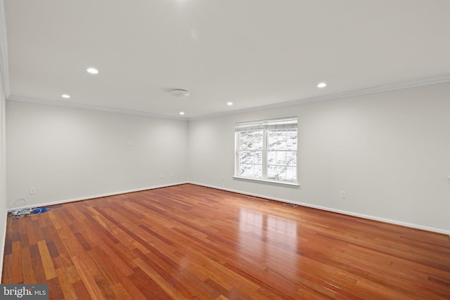 empty room featuring crown molding and wood-type flooring