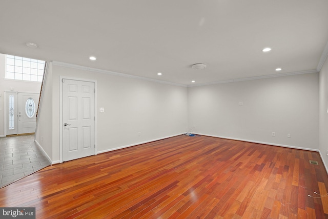 spare room featuring crown molding and hardwood / wood-style floors